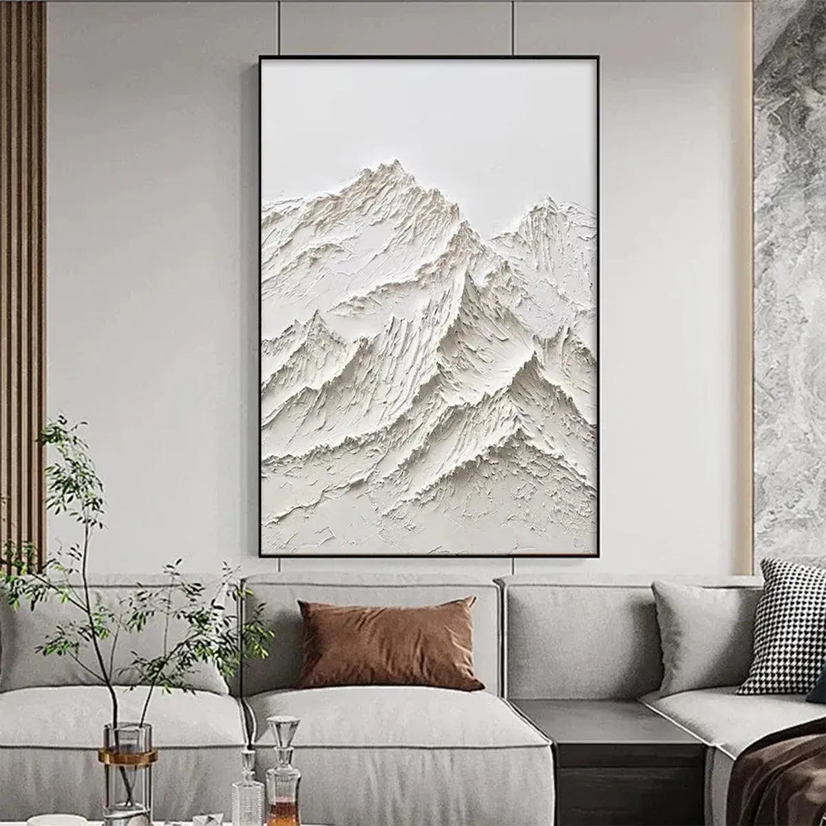 Textured white mountain impasto painting by Liam O'Connell, framed in black, above grey sofa.