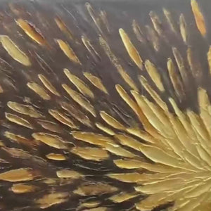 Textured abstract painting with gold burst on black background. Impasto technique.